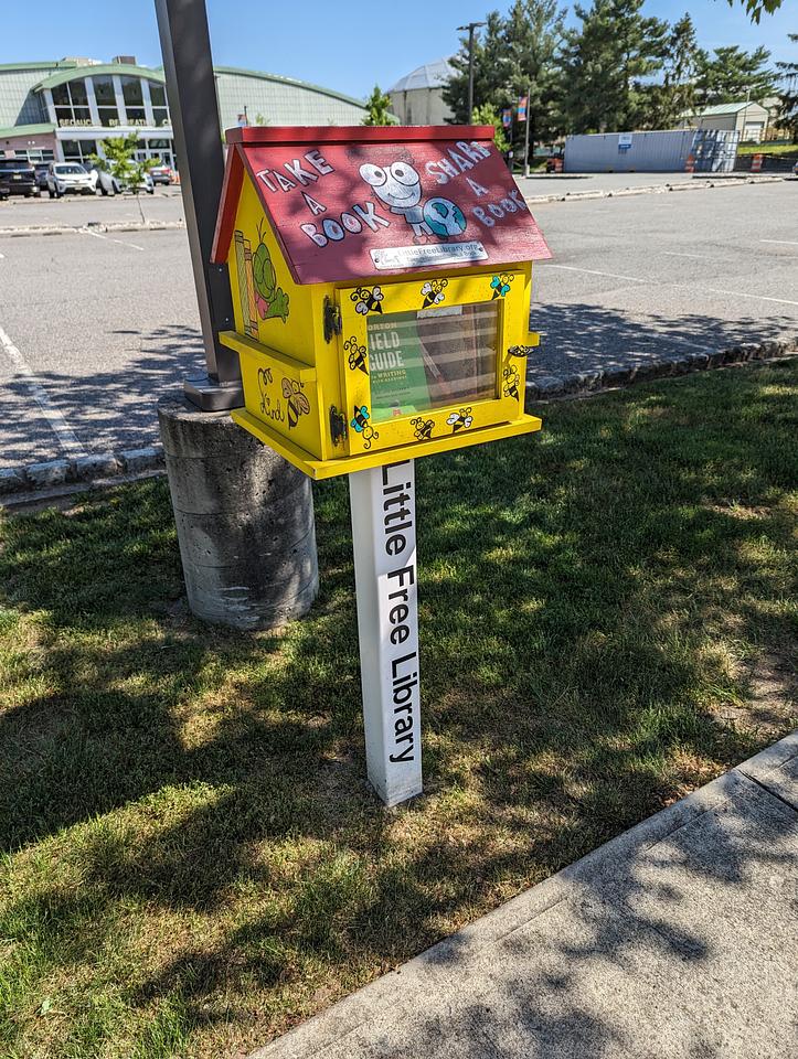 Little Free Library outside the Secaucus Rec Center.  Yellow with a red roof.