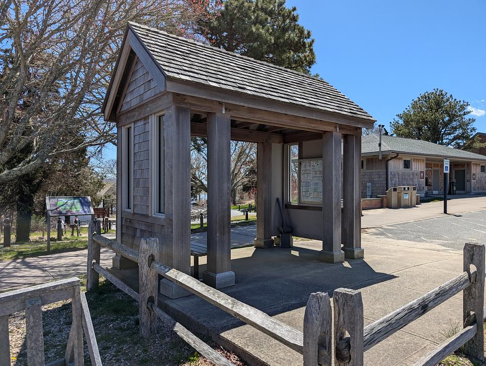 Wooden bus stop with information about the transit lines.  Open front and back.