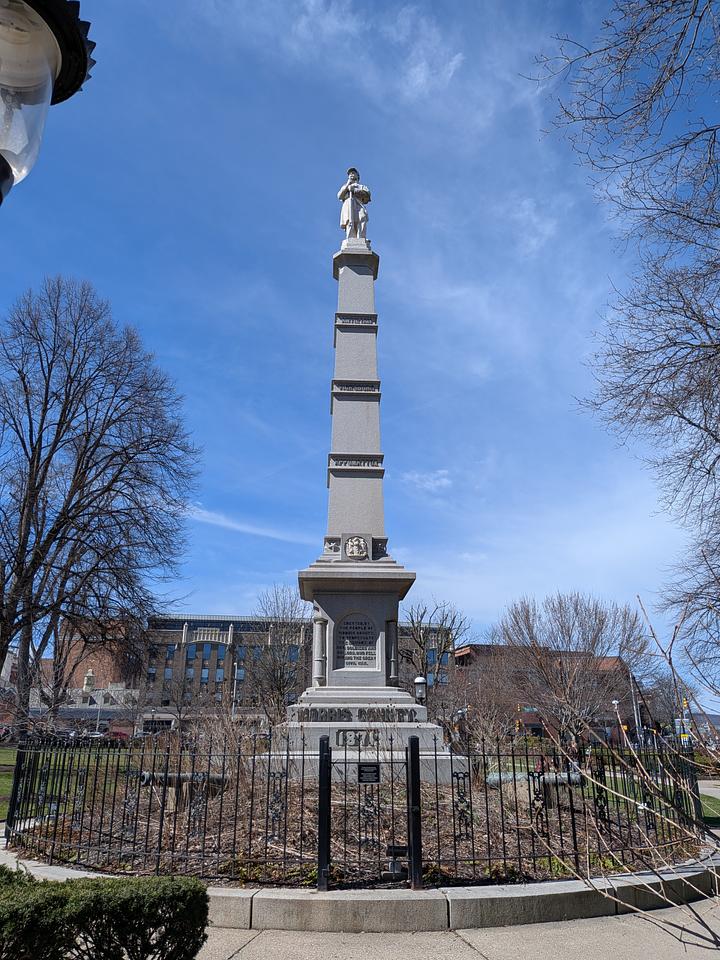 Tall granite monument commemorating the Civil War. Features and 8ft tall solder atop a 40ft column.  A light pole is visible in the left side of the photo.